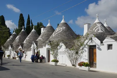 ALBEROBELLO, ITALY - JULY 31, 2017: Beautiful town of Alberobello with  trulli houses among green plants and flowers, main touristic district,  Apulia r Stock Photo - Alamy