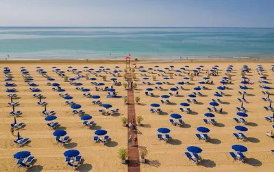 BIBIONE, ITALY - APRIL 30, 2018: Couple of tourists walking on a beach on a  sunny day Stock Photo | Adobe Stock