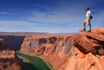 Couple sitting nuzzling on edge of Grand Canyon, Arizona, USA stock photo