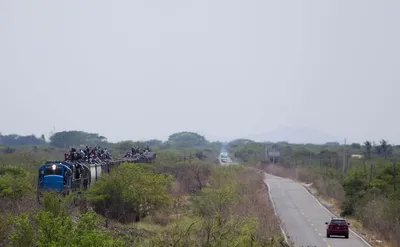 Мигранты взобрались на пограничный забор между Мексикой и США