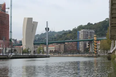 Вид Бильбао, Испания Города Города С Рекой Nevion, Zubizuri Bridge И  Набережной. Горный Массив В Фоновом Режиме, Чистое Голубое Небо.  Фотография, картинки, изображения и сток-фотография без роялти. Image  38284310