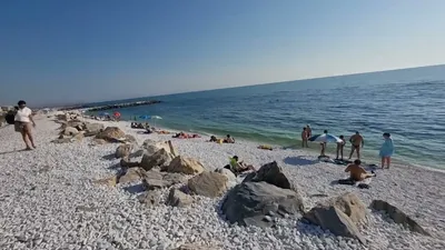 MARINA DI PISA, ITALY - Avril 24, 2017: View Of The Sea And The Beach Of  White Pebbles, People Take The First Sun Of The Season In Marina Di Pisa  Tuscany Stock