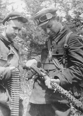 Два советских партизана осматривают трофейный немецкий пулемет MG-34 —  военное фото